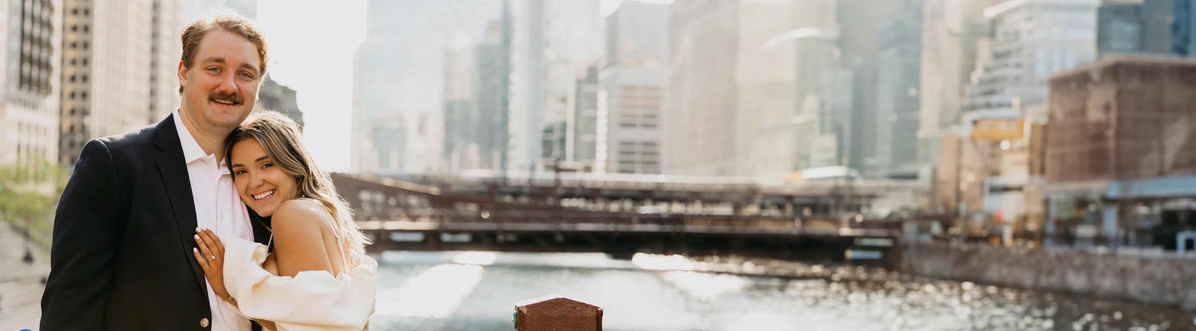 Couple having engagement pictures taken in front of a bridge