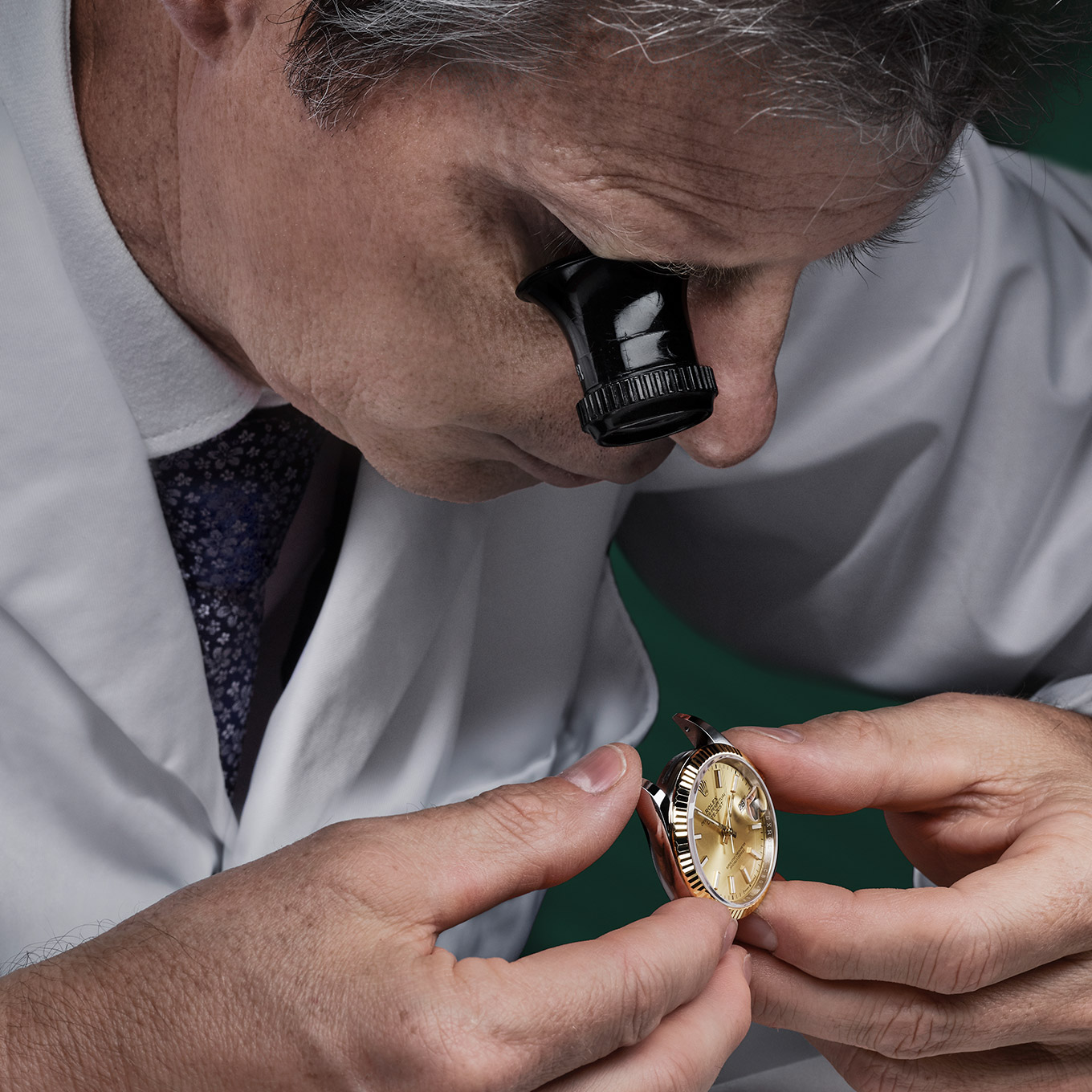 rolex watch being assessed by man with monocle viewer