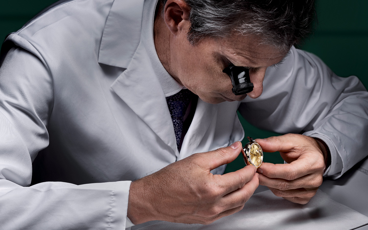 Man viewing rolex watch up close with magnifier