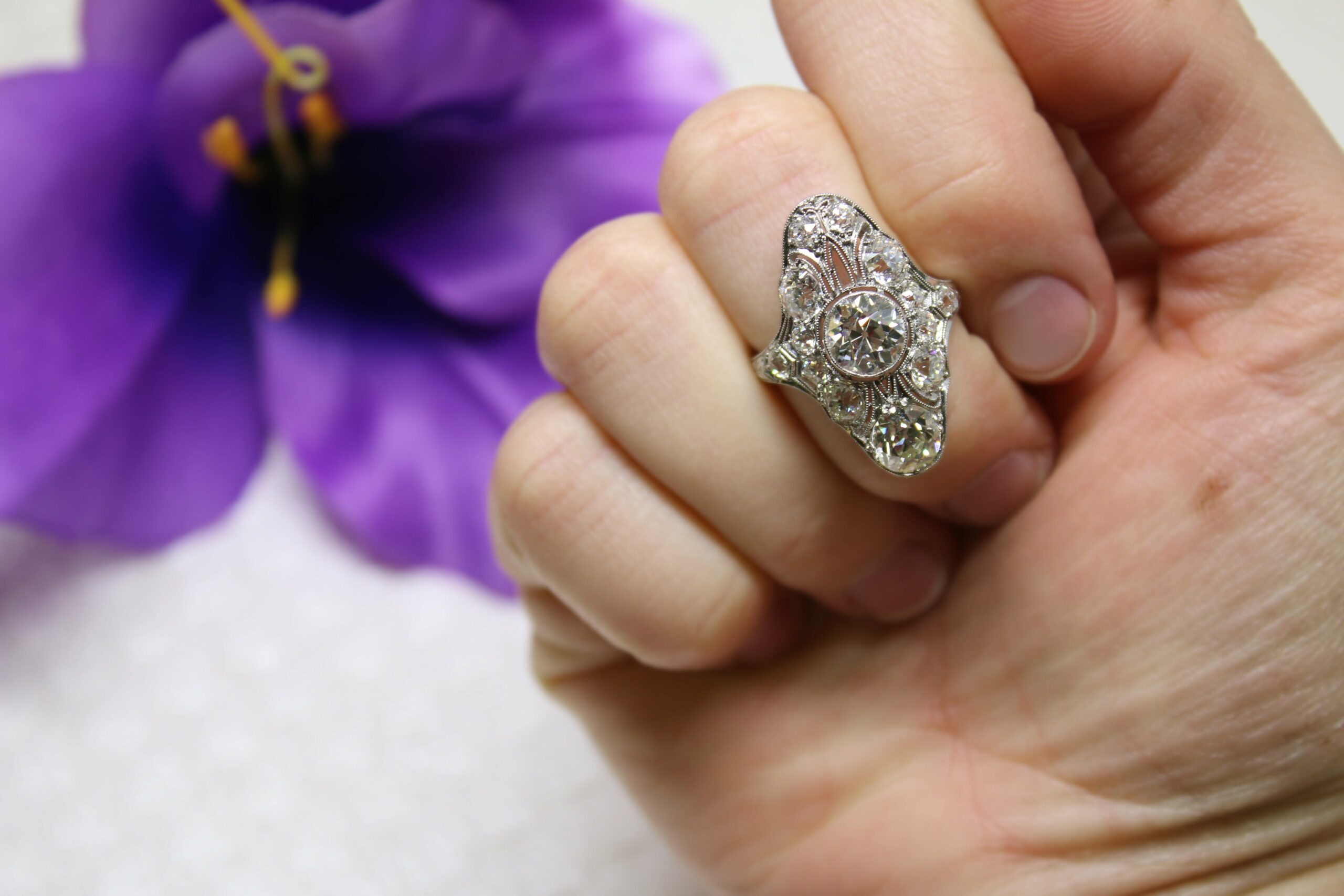 A huge Edwardian style diamond ring on a hand.