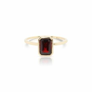 This solitaire garnet ring by Rafael is crafted from 14k yellow gold and features a 1.25 carat emerald cut garnet.