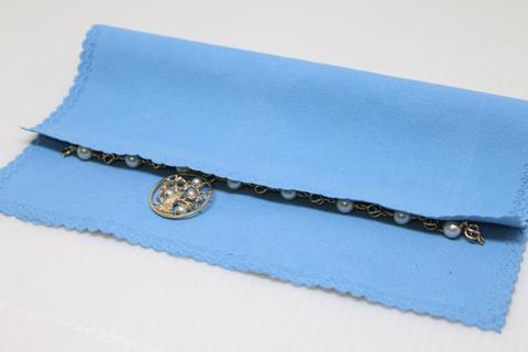 A necklace laid on a blue cloth.