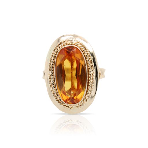 This citrine ring is crafted from 14k yellow gold and features an oval citrine with a rope halo.