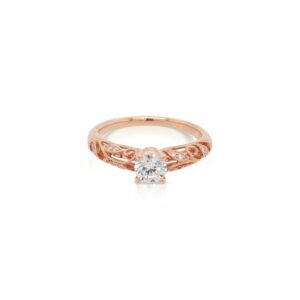 This diamond engagement ring mounting by Sylvie is crafted from 14k rose gold and features 0.12 total carats of diamonds scatered throughout the elegant filigree design. The center diamond is chosen separately.