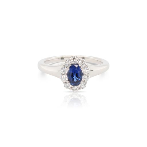 This sapphire and diamond ring by Spark Creations is crafted from 18k white gold and features a 0.60 carat oval sapphire and 0.40 total carats of diamonds around the halo.
