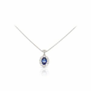 This sapphire and diamond necklace by Spark Creations is crafted from 18k white gold and features a 0.60 carat oval sapphire and 0.40 total carats of diamonds around the halo.