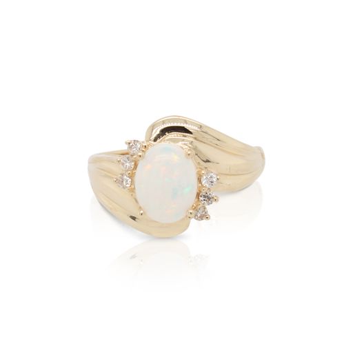 This opal and diamond ring is crafted from 14k yellow gold and features an oval opal and 6 diamonds accents.