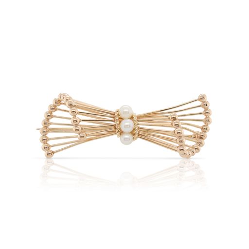 This stylized bow pin is crafted from 14k yellow gold and features 3 pearls.