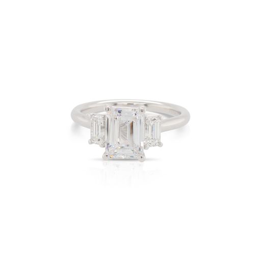 This diamond engagement ring mounting by Alyssa is crafted from 18k white gold and features 0.66 total carats of emerald cut side diamonds. The center diamond is chosen separately.