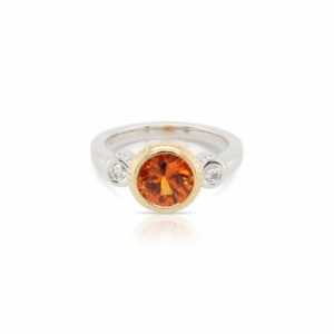 This ring by R.F. Moeller Designs is crafted from 18k white and yellow gold and features a 2.02 carat round mandarin sapphire and 0.11 total carats of diamonds.