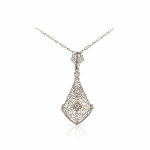 This pendant is crafted from 14k white gold and features 0.15 total carats of diamonds a delicate filigree pattern.