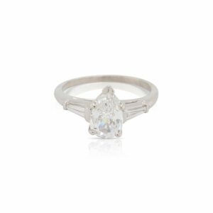 This ring is crafted from platinum and features a 1.05 carat pear shaped diamond and 0.30 total carats of tapered baguette side diamonds.