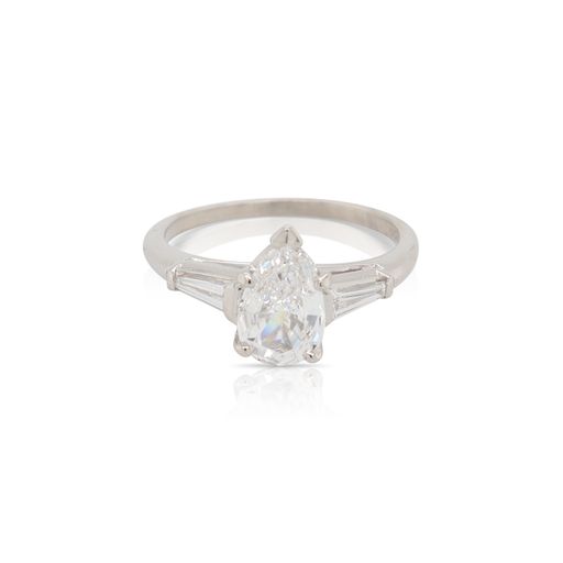 This ring is crafted from platinum and features a 1.05 carat pear shaped diamond and 0.30 total carats of tapered baguette side diamonds.