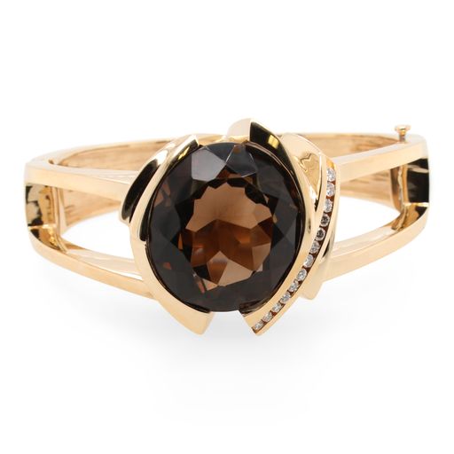 This bangle bracelet is crafted from 14k yellow gold and features a large oval smoky quartz and 0.26 total carats of diamonds.