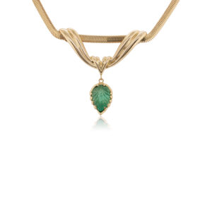 This necklace is crafted from 18k yellow gold and features a carved emerald.