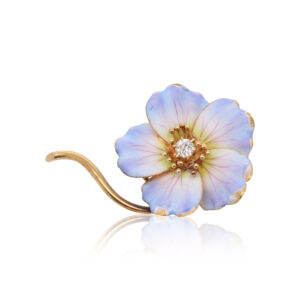 This pansy pin is crafted from 18k yellow gold and features light purple enamel petals surrounding a 0.10 carat old European cut diamond.