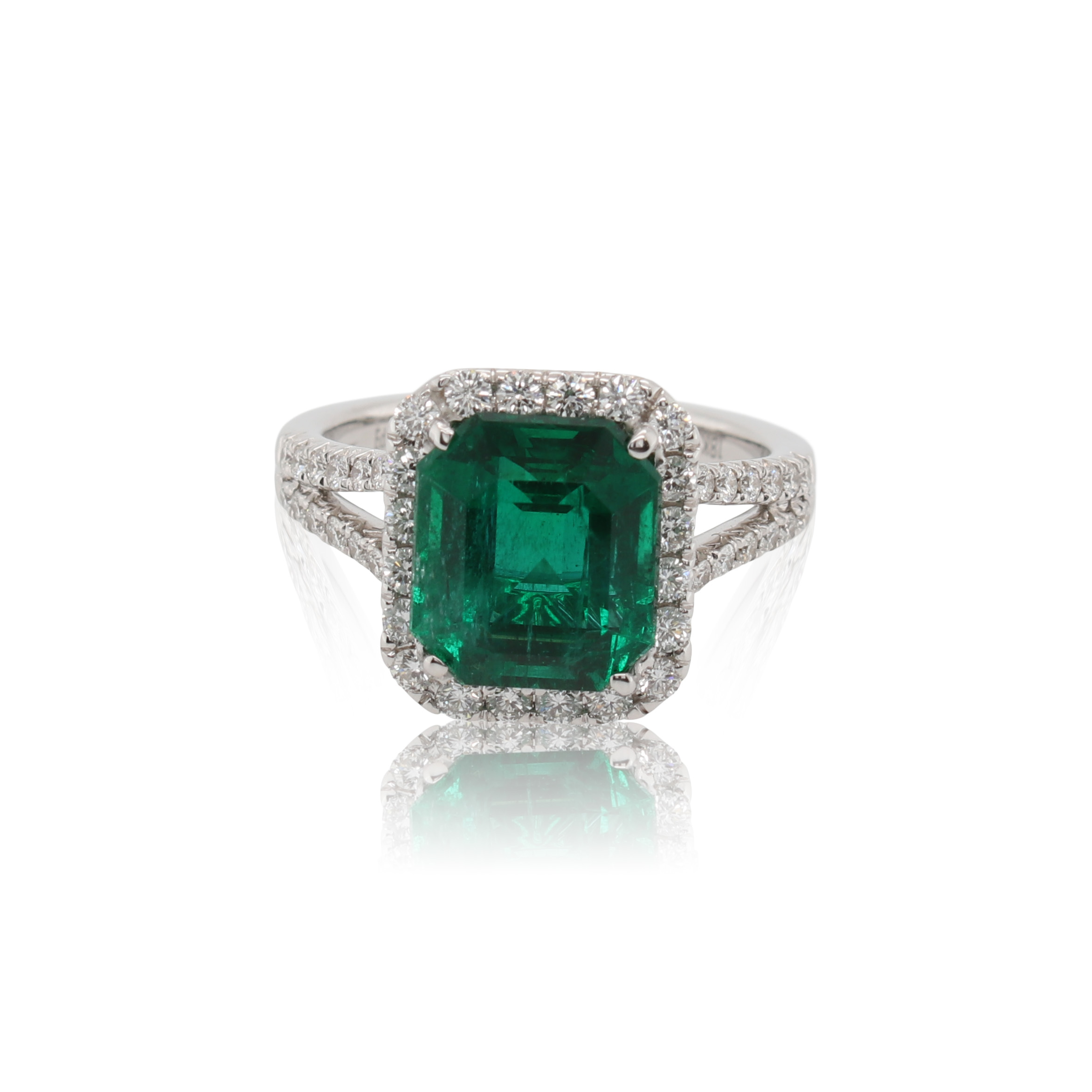 This ring is crafted from 18k white gold and features a 3.75 carat emerald and 0.90 total carats of diamond along the split shank and around the halo.