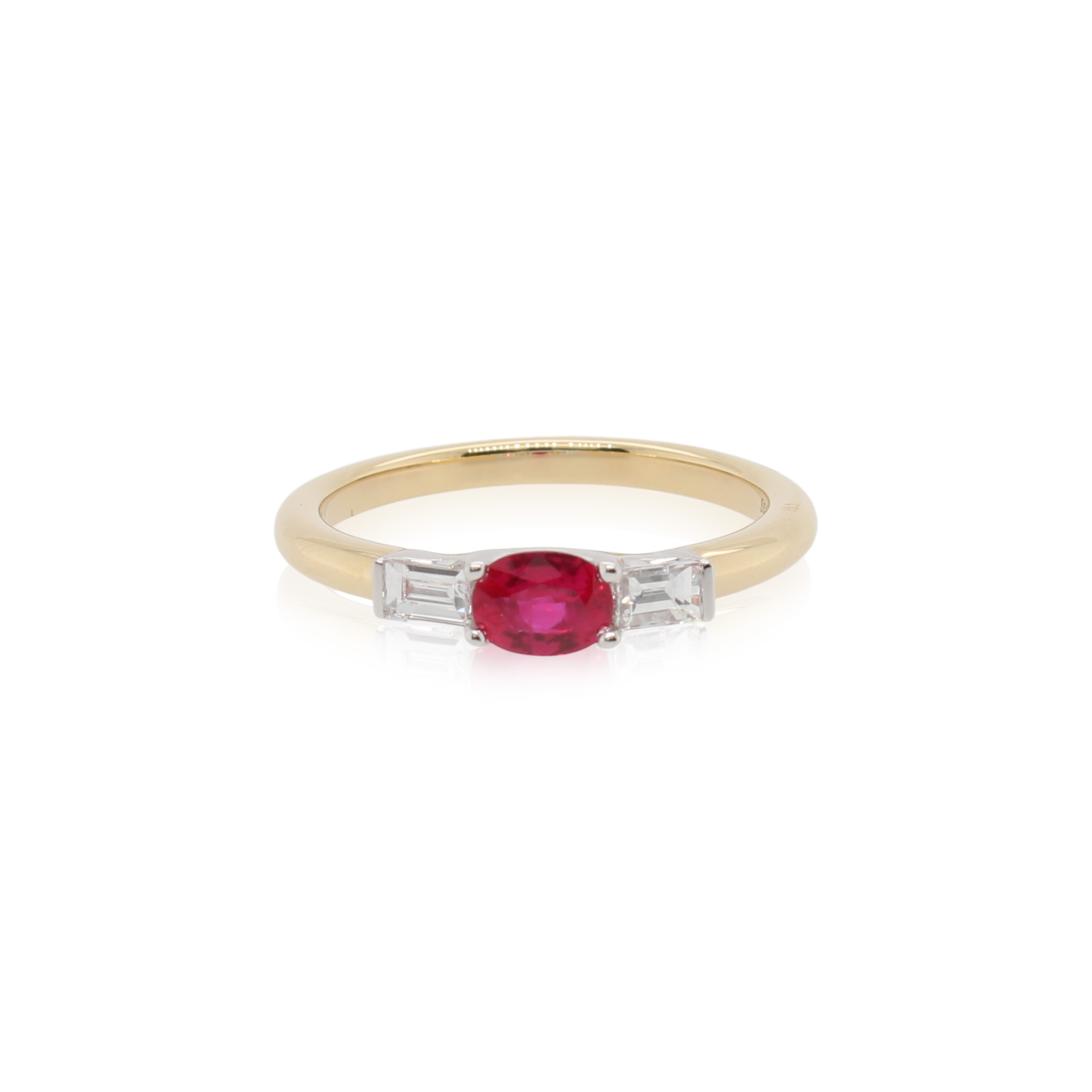 This ring by Spark Creations is crafted from 18k white and yellow gold and features a 0.50 carat oval ruby and 0.23 total carats of emerald cut side diamonds.