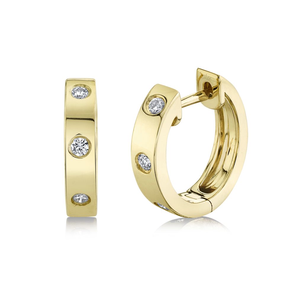 This pair of huggie hoop earrings is crafted from 14k yellow gold and features 0.11 total carats of diamonds.