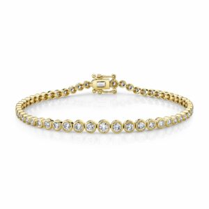 This tennis bracelet is crafted from 14k yellow gold and features 1.90 total carats of bezel set diamonds.