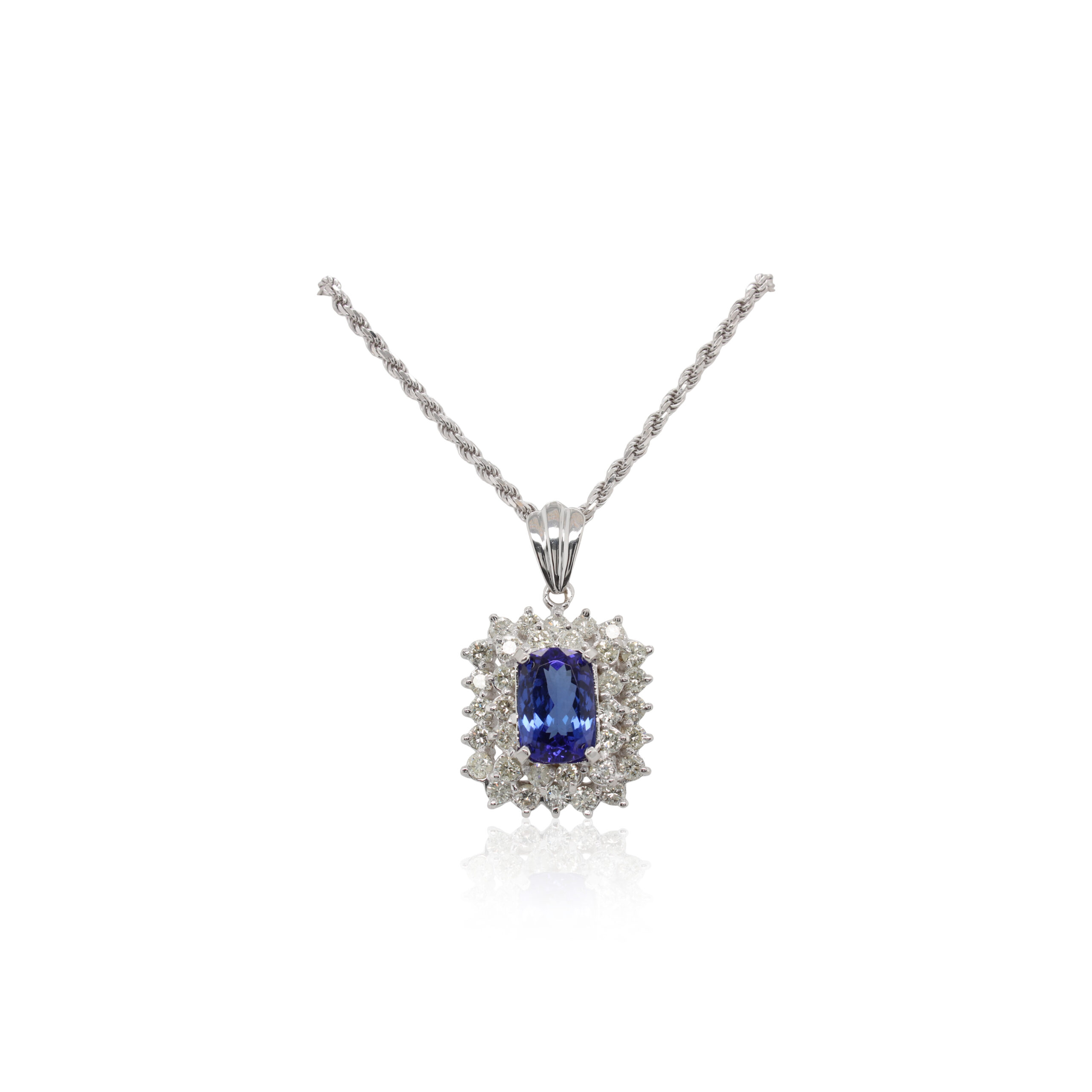 This necklace is crafted from 18k white gold and features an antique cushion tanzanite and 3.40 total carats of diamonds around the double halos. This piece includes a 14k white gold rope chain.